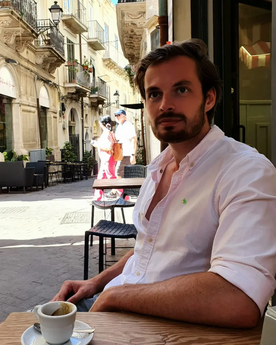 Niels Klaassens aan een tafeltje op een terras in Italië
