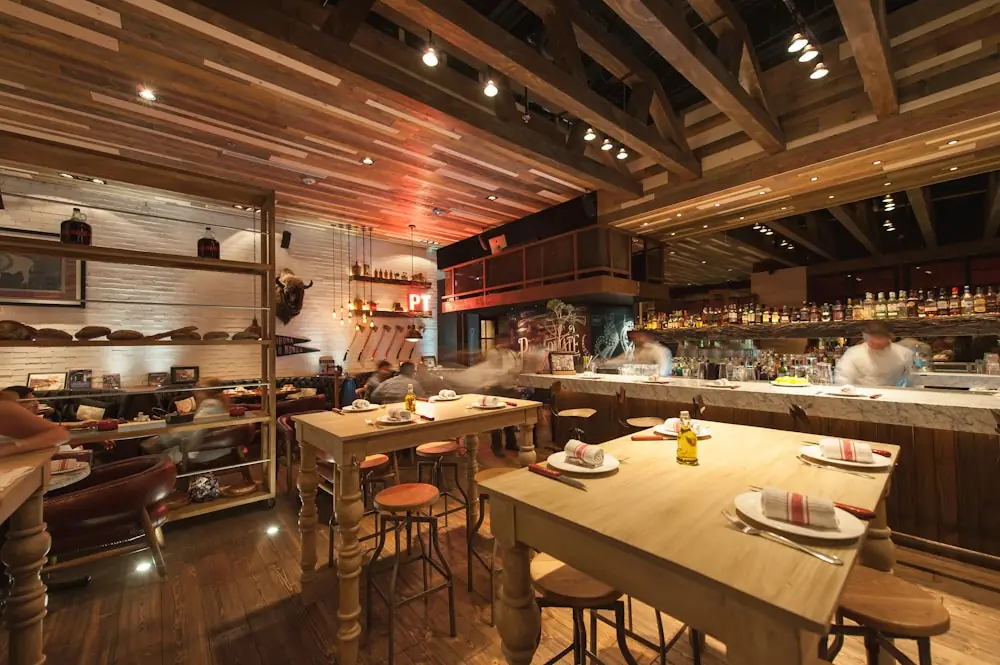 Warm verlicht interieur van de bistro met houten tafels en stoelen